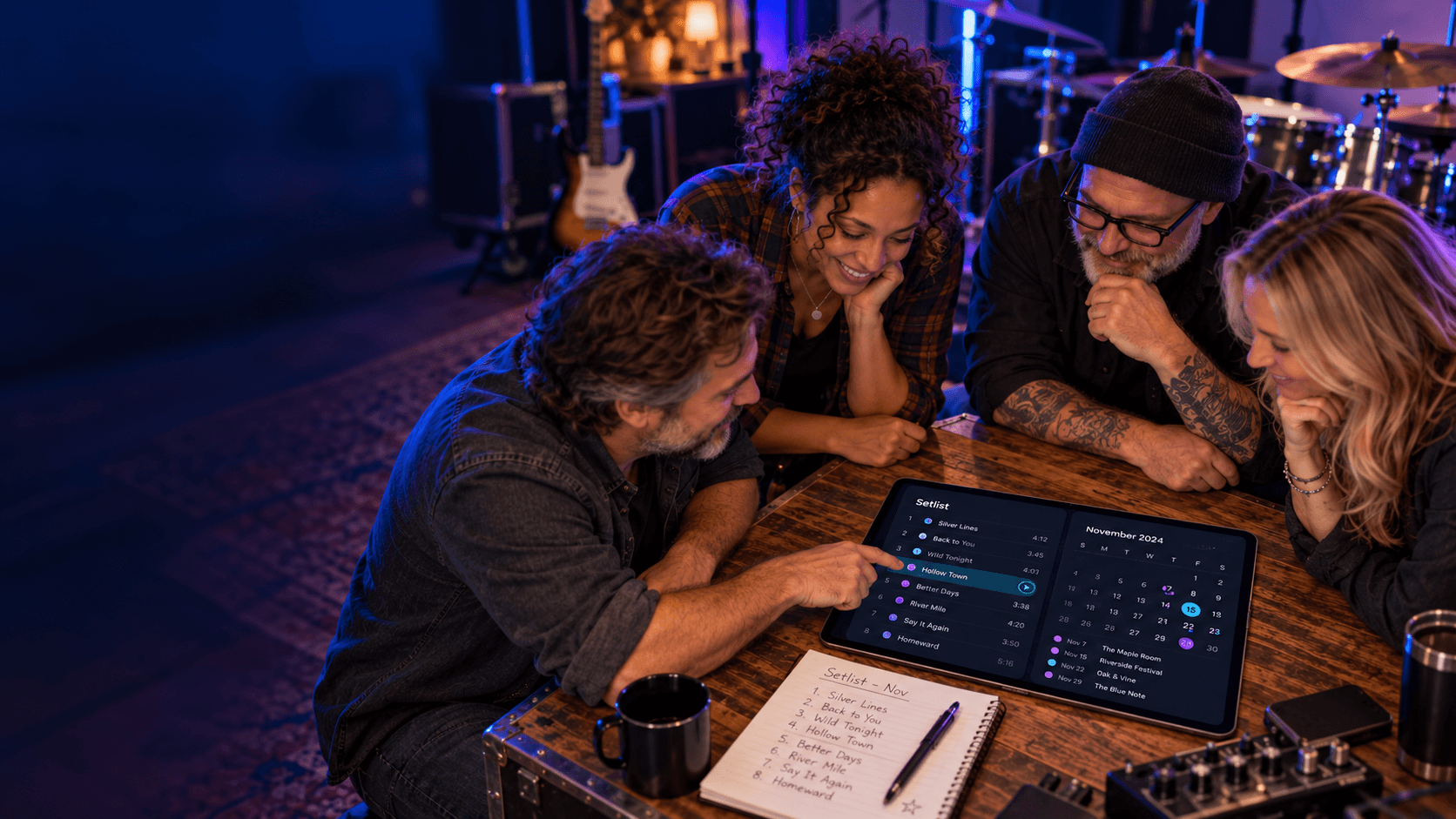 Bandmates planning setlists and a calendar together around a tablet